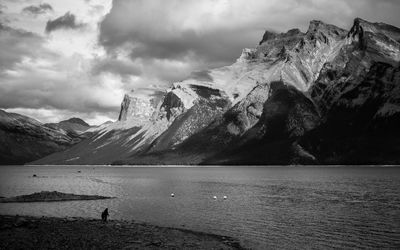 Scenic view of sea by mountains against sky