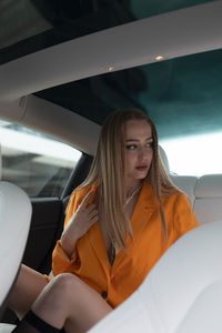 Portrait of young woman sitting in car