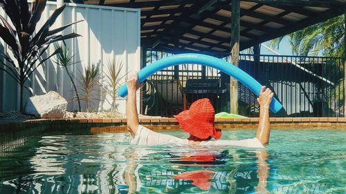 Rear view of man swimming in pool