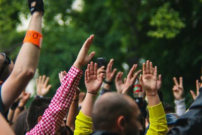 People with arms raised at music concert