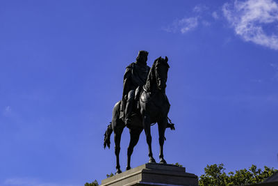 Low angle view of statue against blue sky