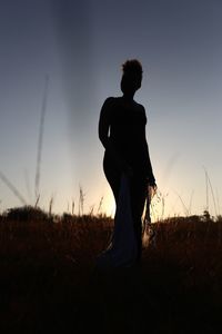 Silhouette woman standing on field against clear sky