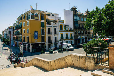 Buildings by street in city against sky