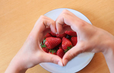 Midsection of woman holding strawberry