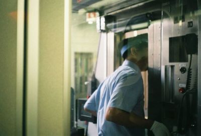 Rear view of man working at train