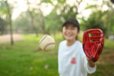 Portrait of woman playing with ball on field
