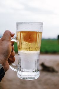Close-up of hand holding beer glass