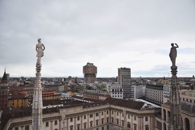 Cityscape against cloudy sky