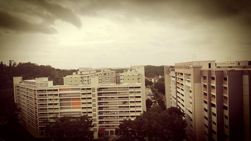 Buildings in city against cloudy sky