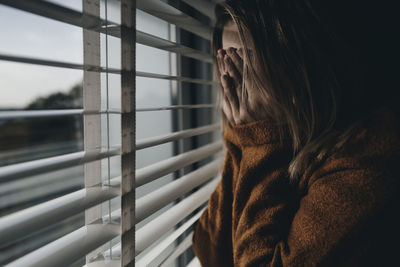 Rear view of woman looking through window