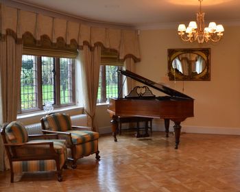 Grand piano by window in illuminated room