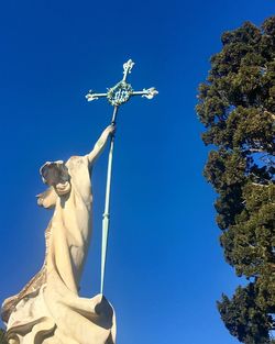 Low angle view of statue against blue sky