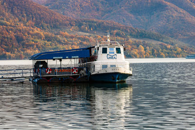 Boat sailing on sea against mountains