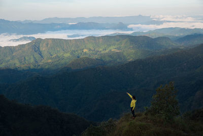 High angle view of woman gesturing on mountain