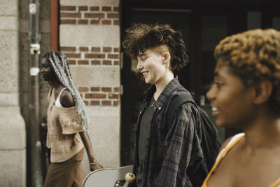 Smiling teenage boy walking with friends in city