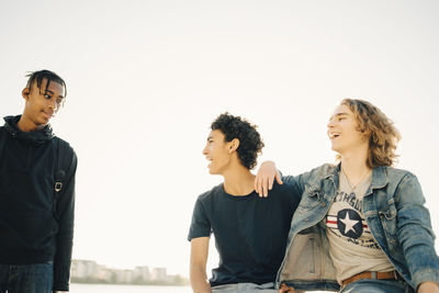 Young couple standing against sky