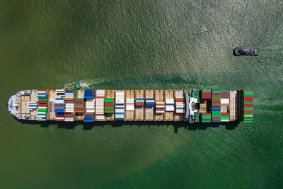 Container ship sailing the ocean, business cargo logistics import export international aerial view