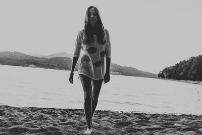 Woman with umbrella walking on lake