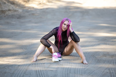 Full length of young woman exercising in gym