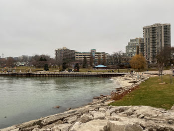 River by buildings against sky in city