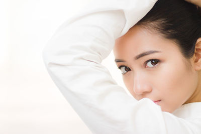 Close-up portrait of young woman posing against white background