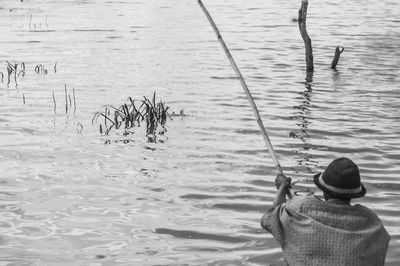 Rear view of man fishing in sea