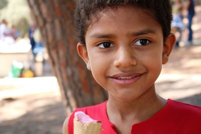 Close-up of smiling boy looking away while eating ice cream