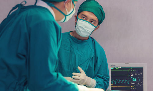 A doctor from asia stands in his operating room office.