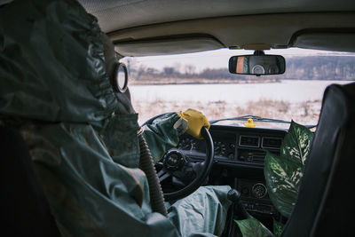 Rear view of man photographing in car