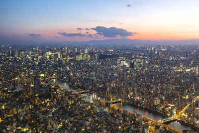 High angle view of illuminated city against sky during sunset