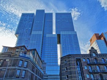 Low angle view of modern buildings against blue sky