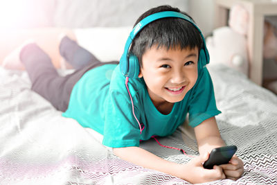 Happy boy lying on bed at home