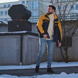 Full length of man standing on snow covered road