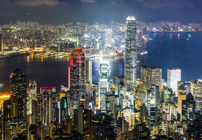 Illuminated cityscape against sky at night