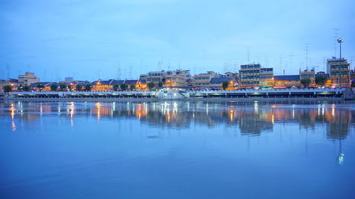 River by buildings against sky at dusk