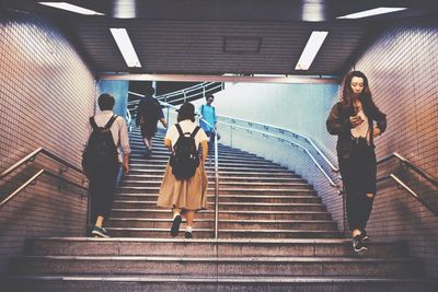 Woman standing on escalator