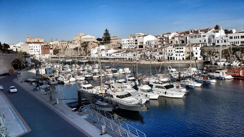 Sailboats in front of buildings against clear sky