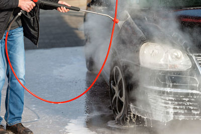 Low section of man washing car