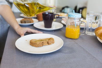 Cropped hand having bread at home