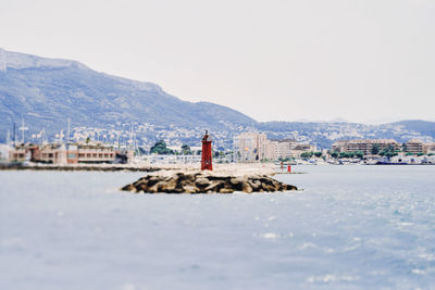 Scenic view of sea and buildings against clear sky