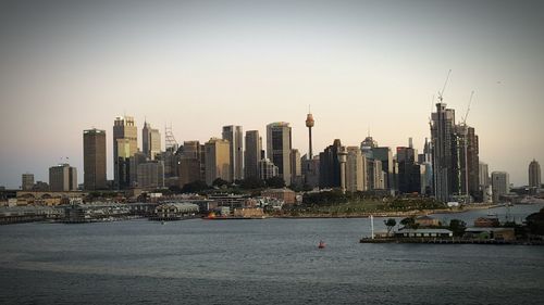 City at waterfront against clear sky
