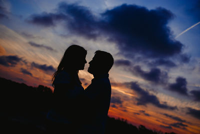 Silhouette couple against sky during sunset