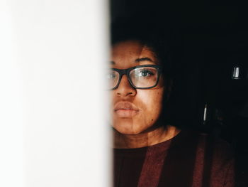 Close-up of young woman with eyeglasses at home