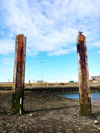 View of wooden post on field against sky