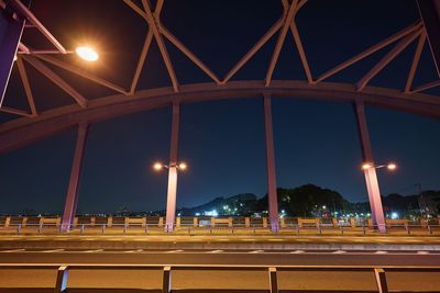 Illuminated bridge against sky at night