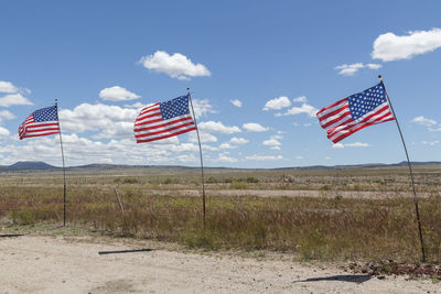 Flag flags on field against sky