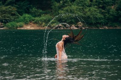 Full length of shirtless man in lake