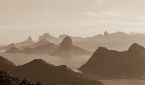 Scenic view of sea and mountains against sky