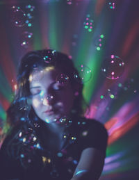 Close-up of woman in illuminated nightclub