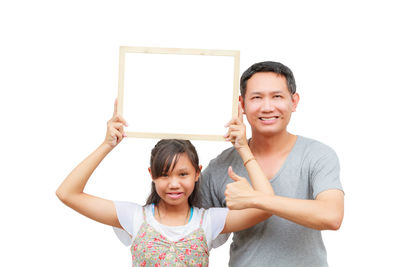 Portrait of smiling girl standing against white background